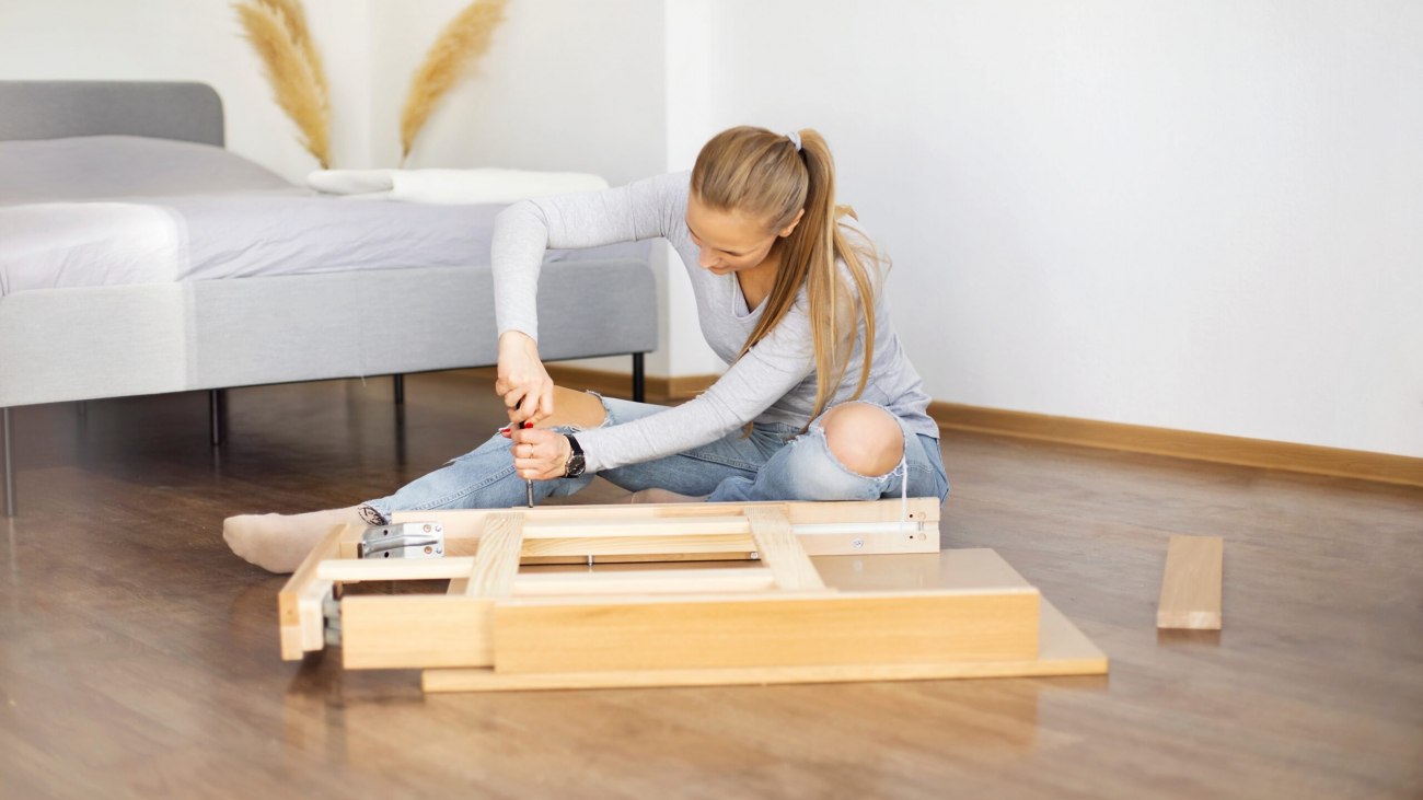 Young woman collects new furniture at home after renovation.