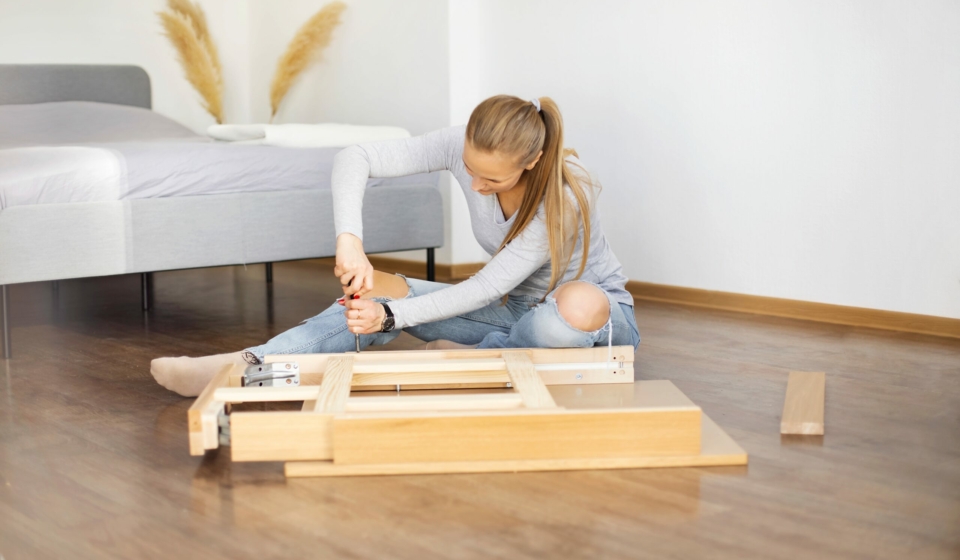 Young woman collects new furniture at home after renovation.