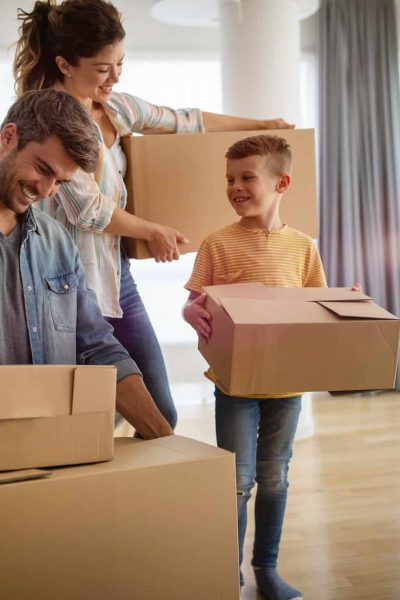 Happy family unpacking boxes in new home on moving day